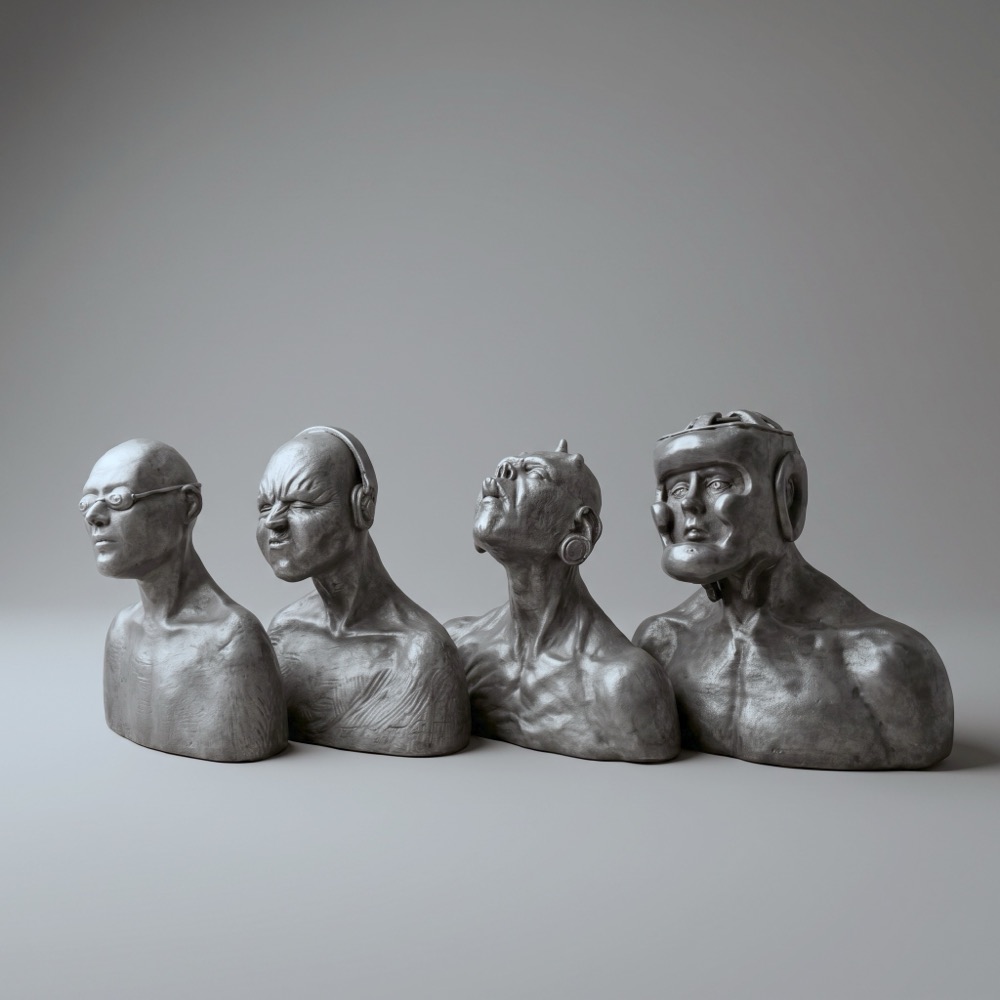 Four small bronze busts of men joined at the shoulders: one in sunglasses, one in headphones, one with his head thrown back, one in a boxing headguard.